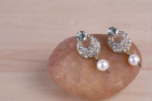Turmalina by Pinal sparkling diamond and pearl earrings elegantly displayed.
