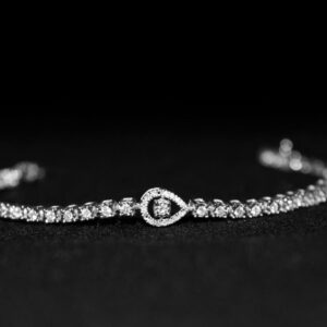 Close-up of a luxurious diamond bracelet with a black backdrop, showcasing elegance.